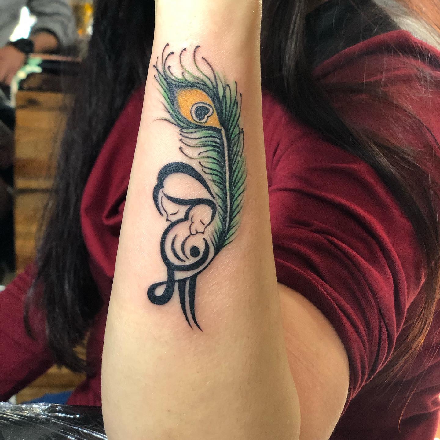Vibrant Peacock Feather on Girls Shoulder Blade