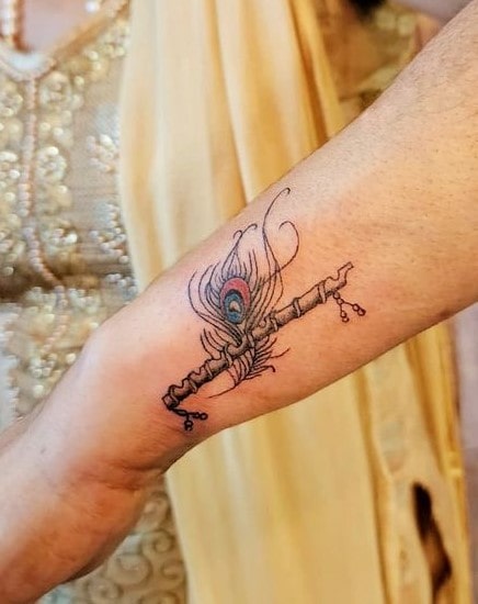 flute With Peacock Feather Tattoo Design| small tattoo | Band tattoo  designs, Feather tattoo design, Hand tattoos