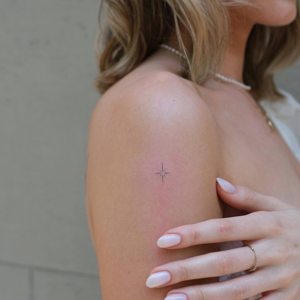 Cute minimalistic north star tattoo on the upper arm starlit style
