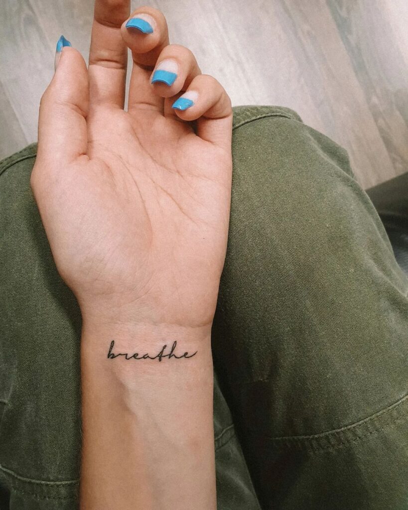 Inspirational ink breathe lettering script tattoo on the inner wrist