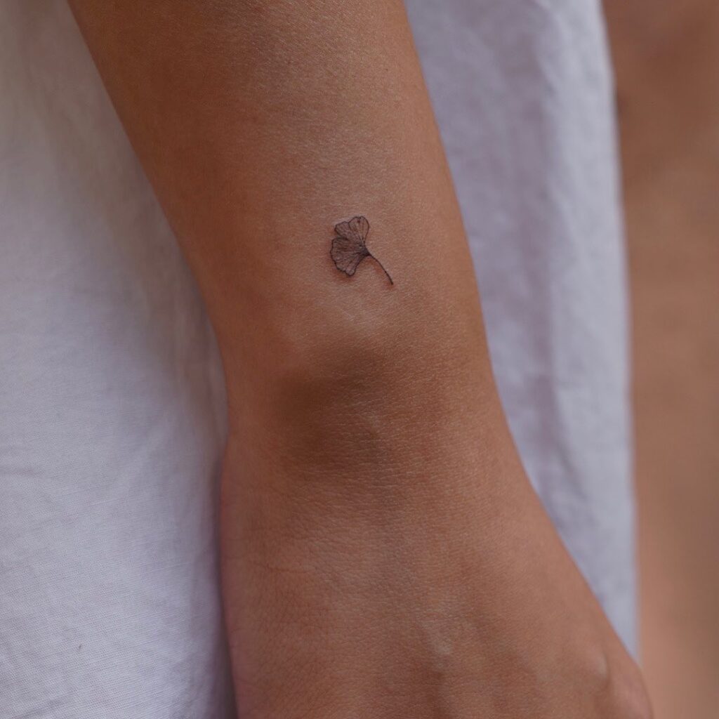 Small ginkgo leaf tattoo on the outer wrist whispers
