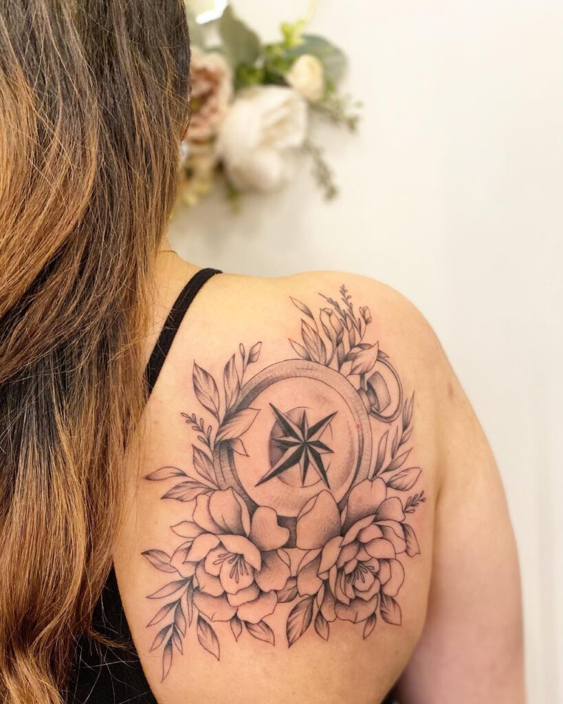 Compass surrounded by flowers on the back of the shoulder floral orientation